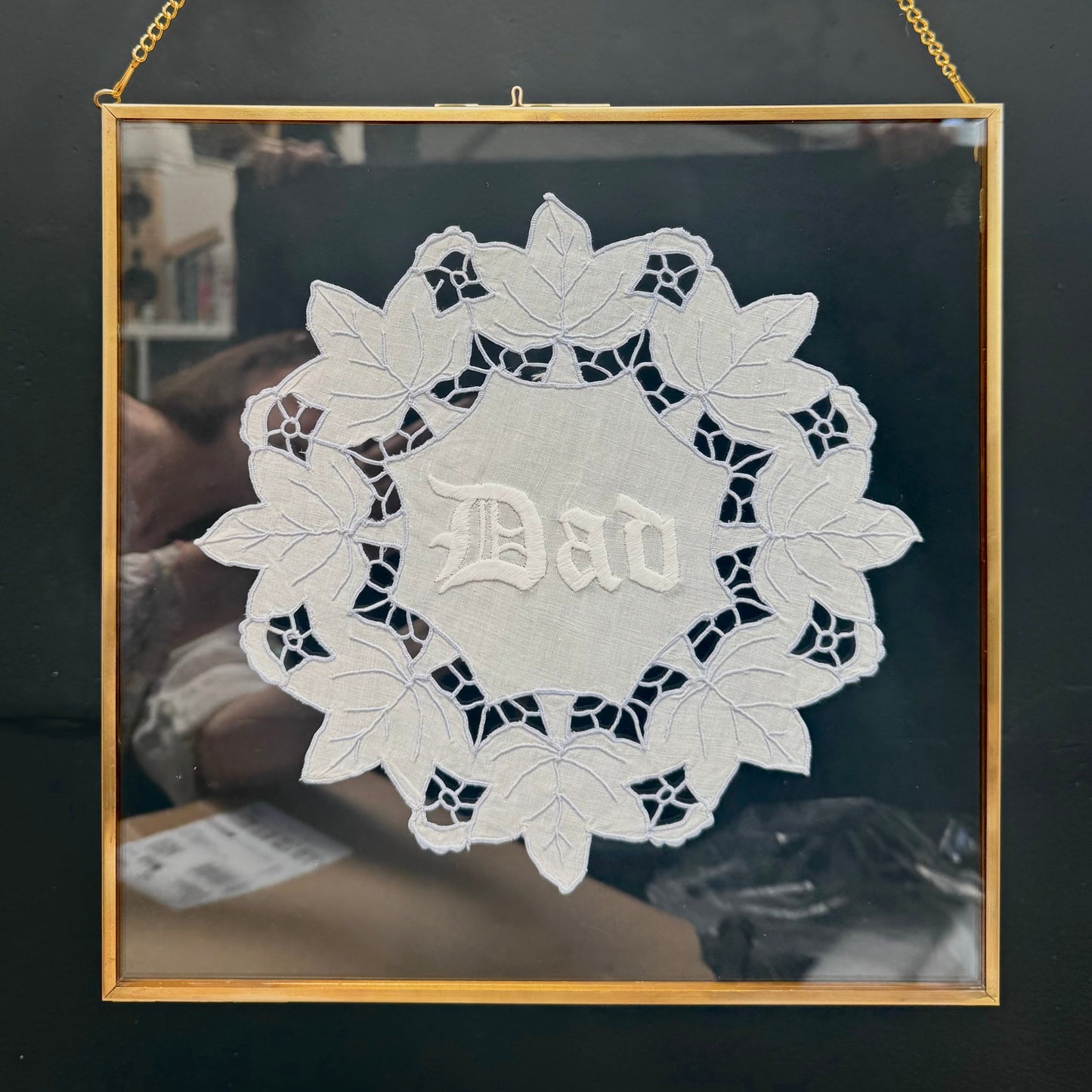 Decorative wall art with 'Dad' in the center, framed in gold against a dark background.