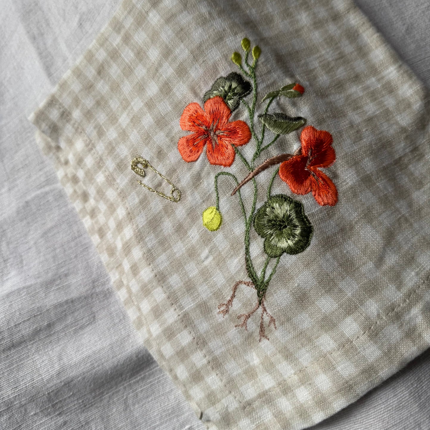 Nastutrium embroiderd napkin on grey linen tablecloth