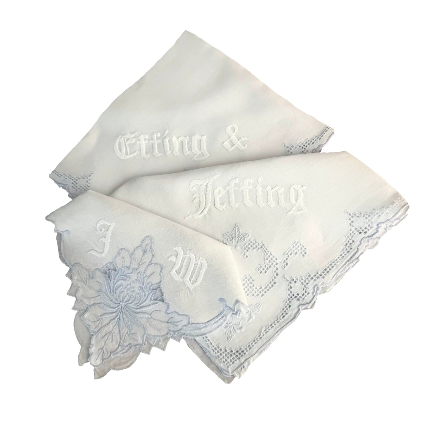 Two white handkerchiefs with embroidered text and floral design on a white background