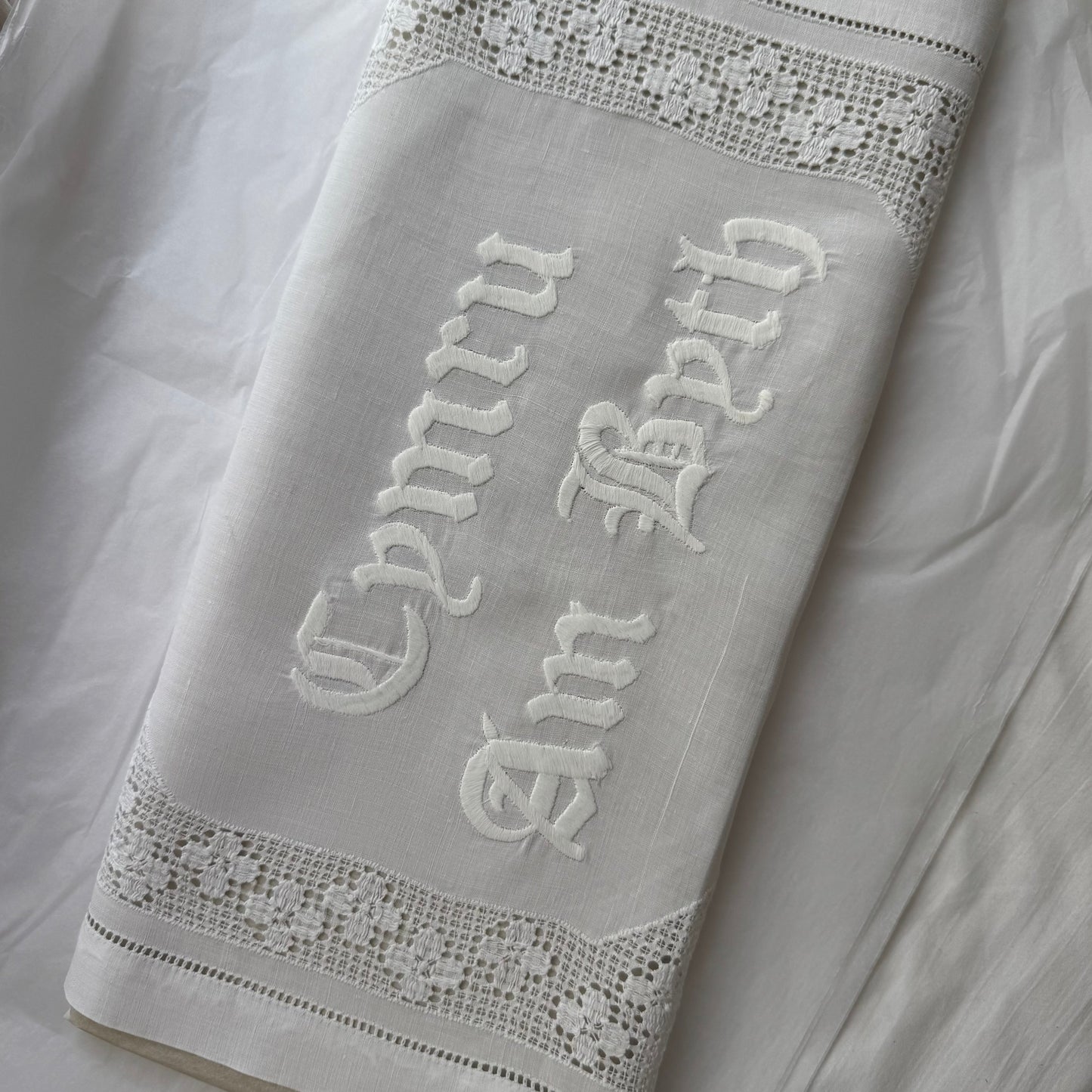 Embroidered text on a vintage fabric with decorative trim