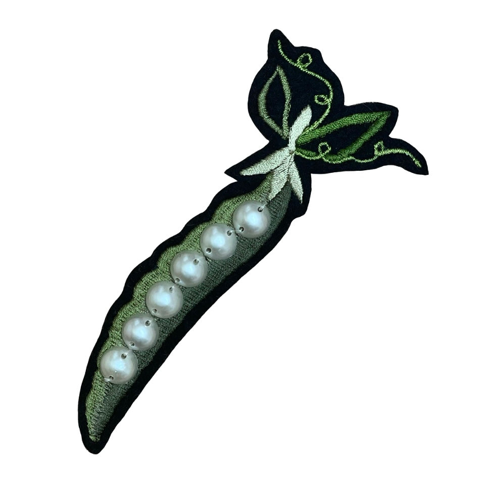 Pea and pearl embroidered patch on a white background