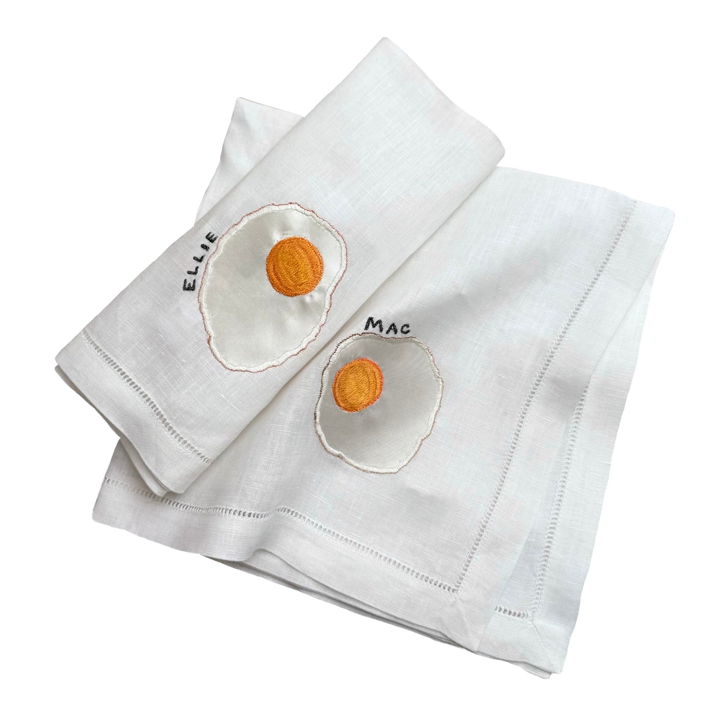 Pair of fried egg napkins on white background