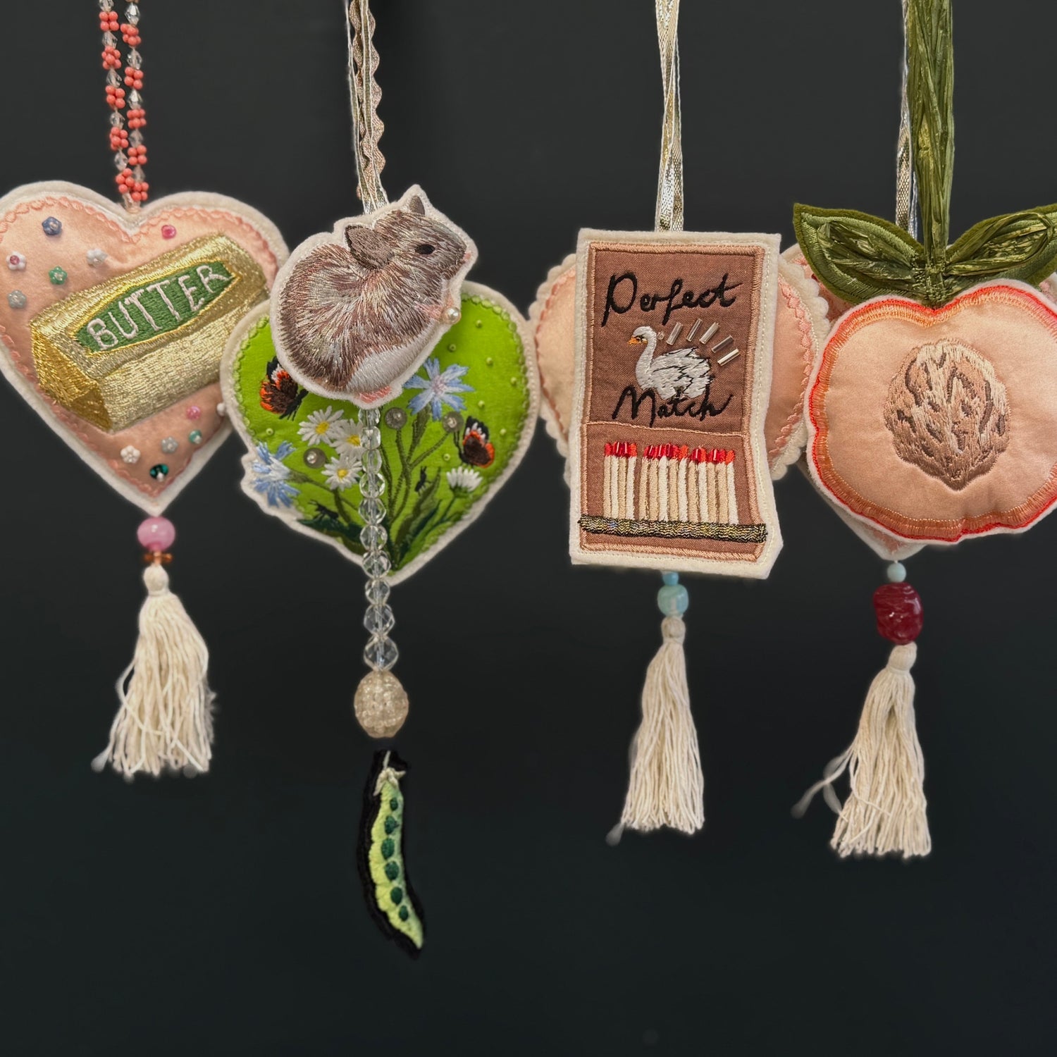 Collection of embroidered ornaments with tassels on a dark background