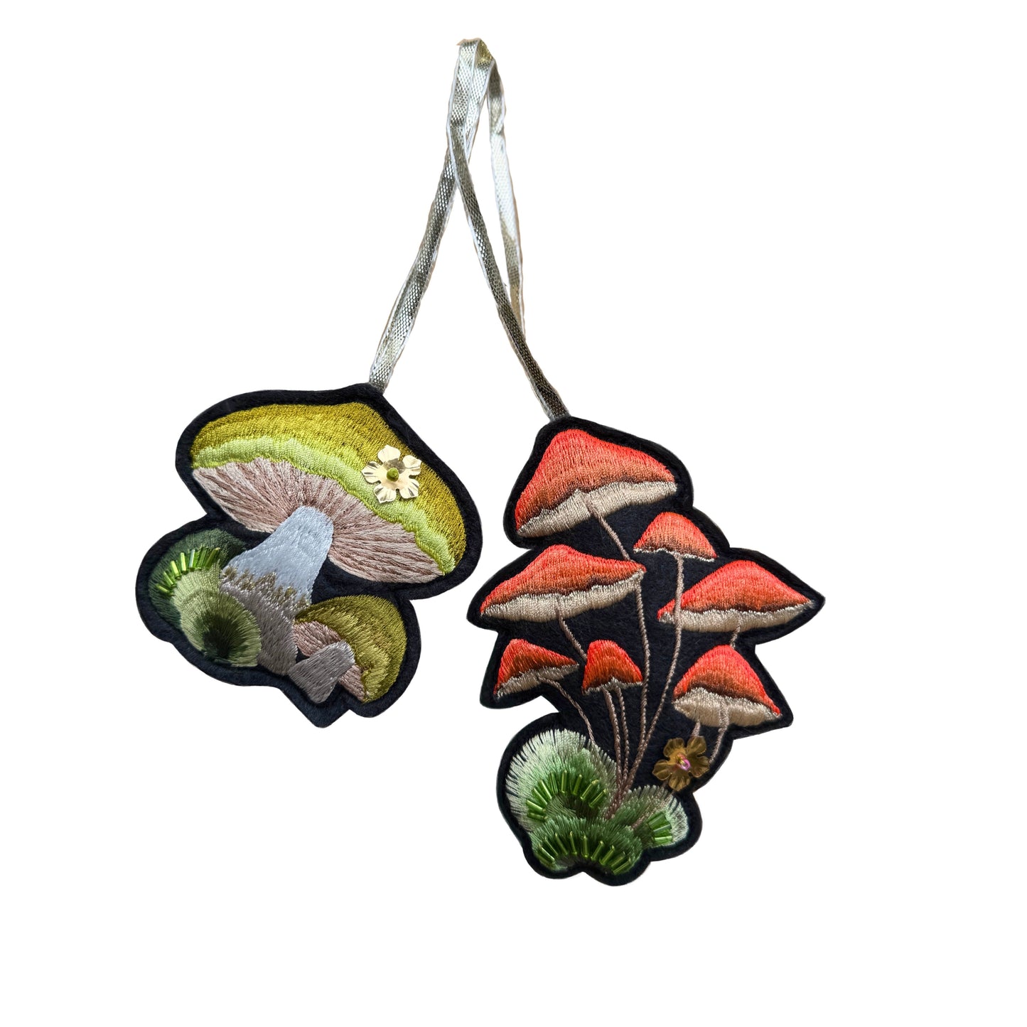 Two embroidered mushroom designs on a white background