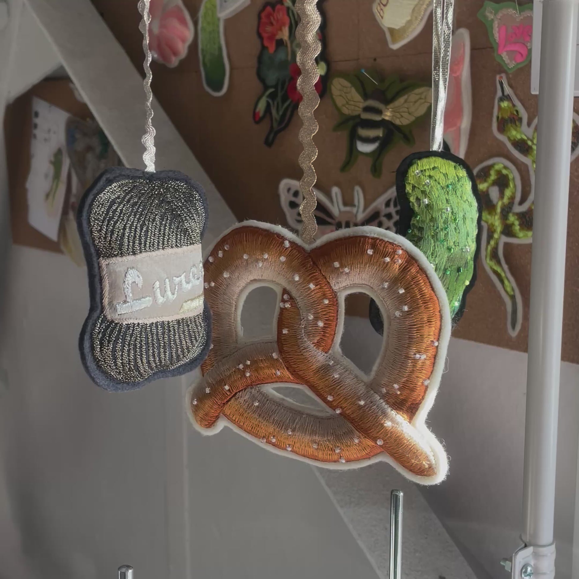 Video shows pretzel decoration hanging with a lurex yarn and glitzy gherkin decoration