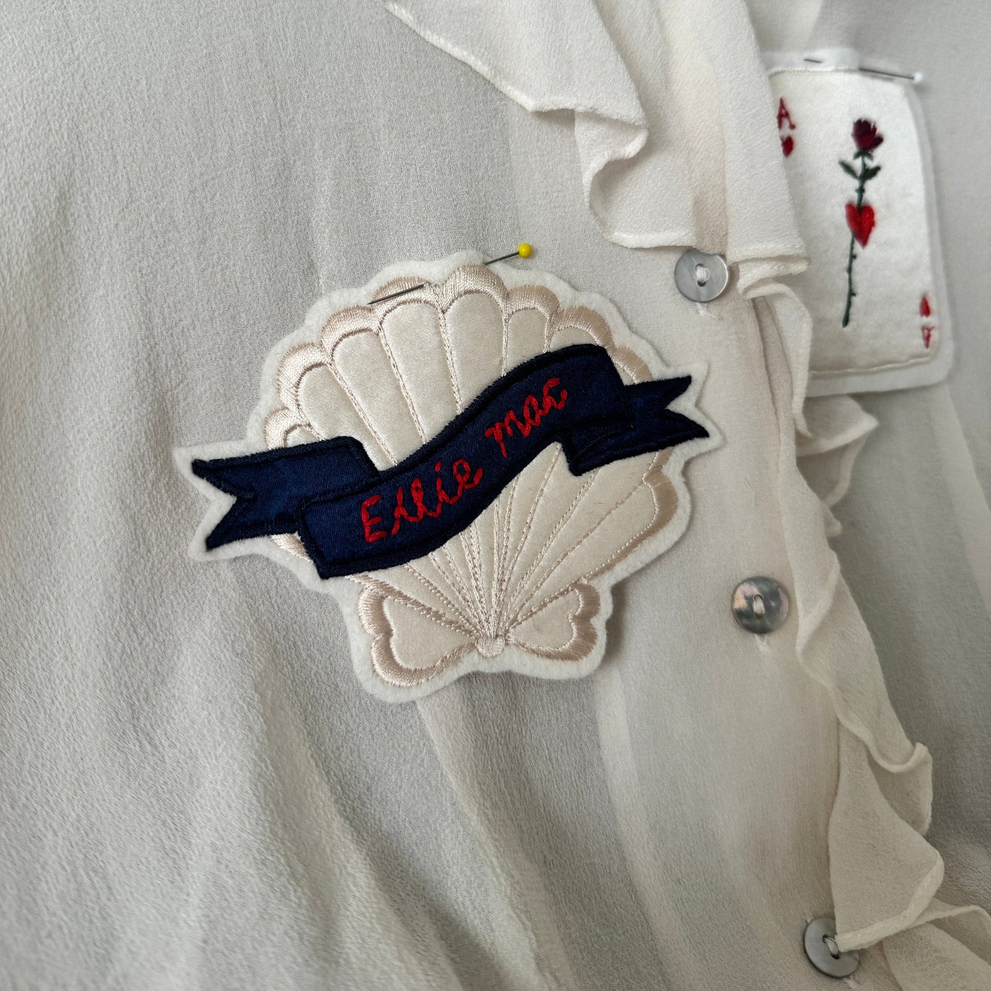 embroidered shell patch on silk blouse