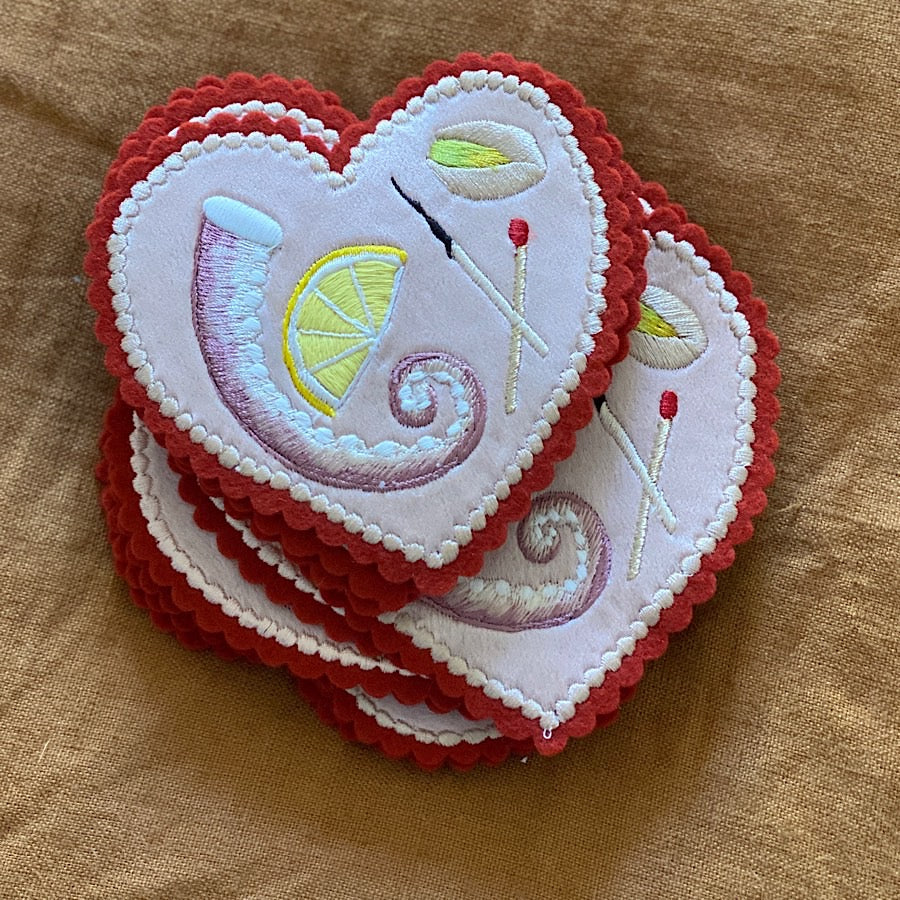 Pile of Minature Platter Embroideries stacked on top of each other and laid on a fabric background
