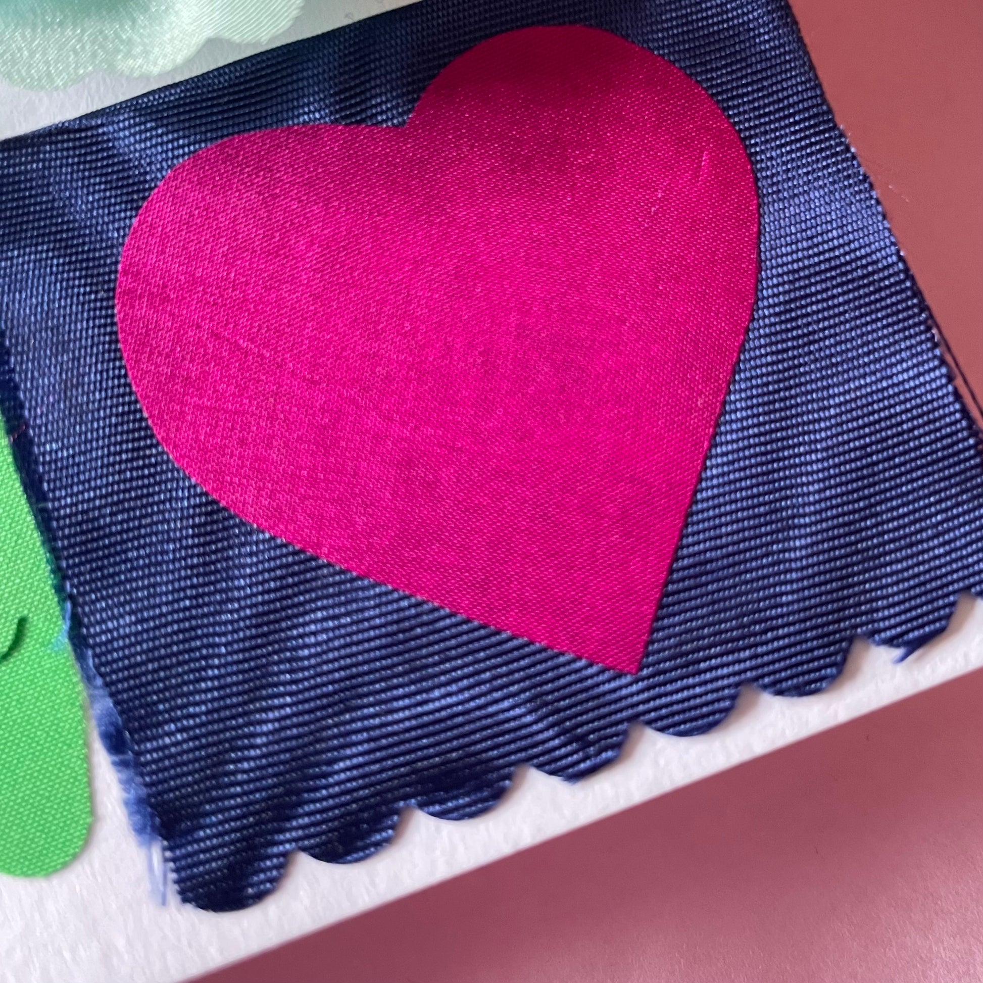 Close-up of the moire blue fabric with a hot pink heart fabric on top