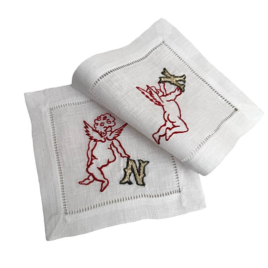 Two white coasters with embroidered designs on a white background