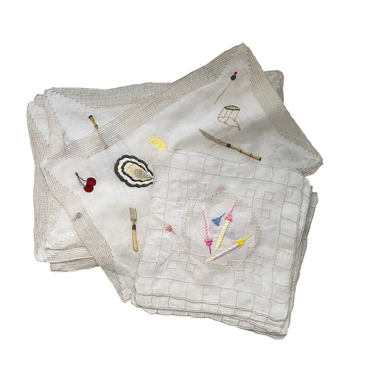Selection of embroidered vintage linens displayed on a white background