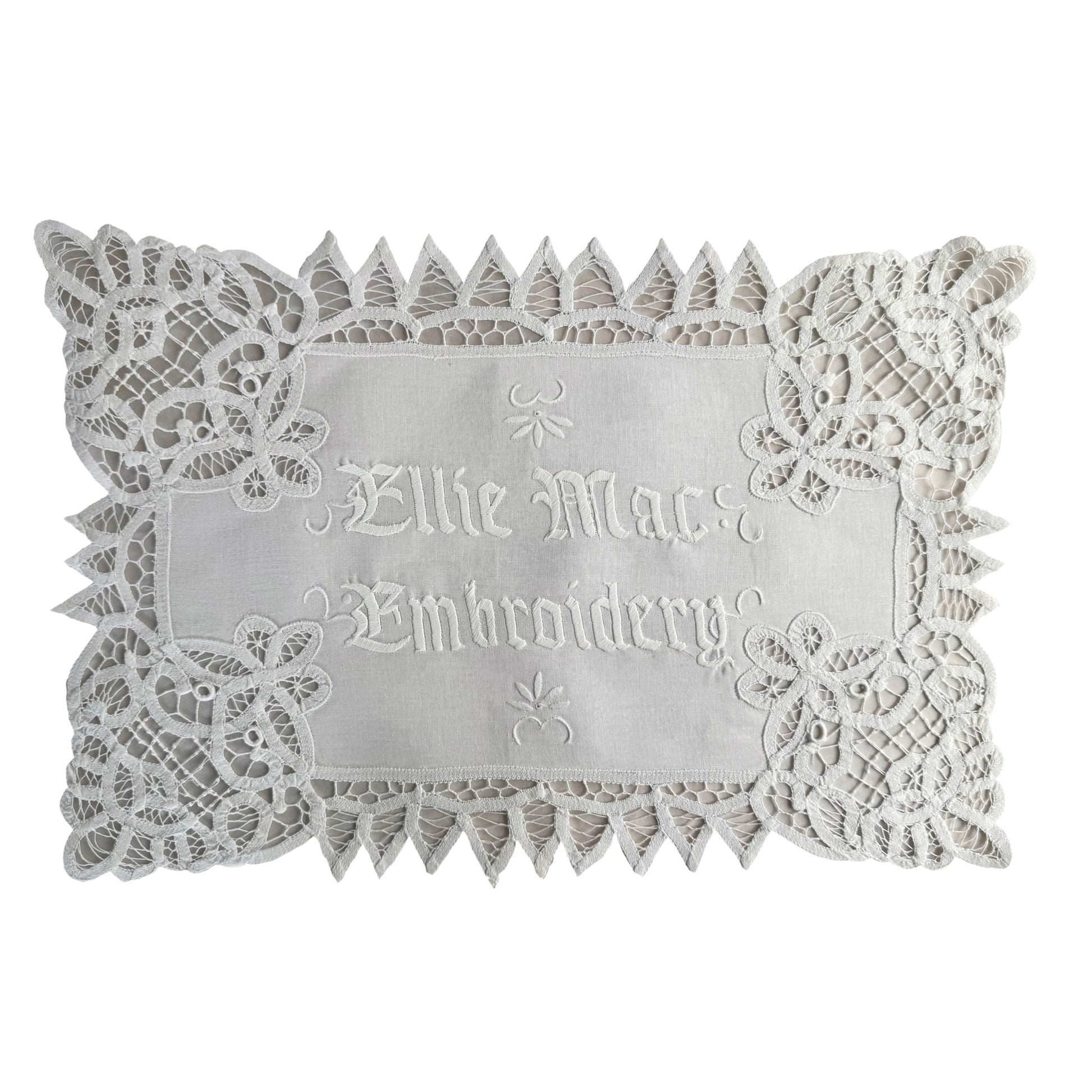 Decorative lace doily with embroidered text on a white background