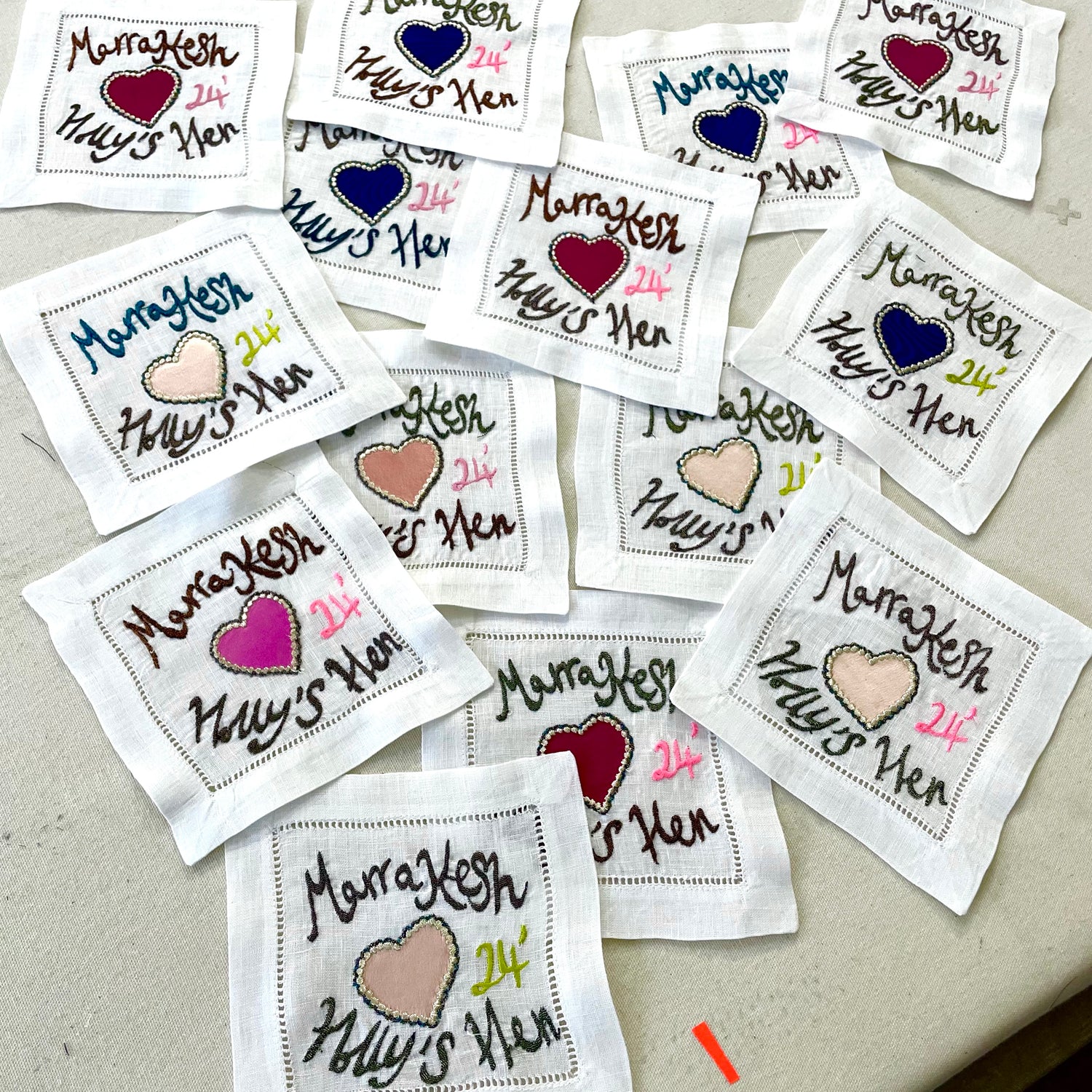 Multiple personalised coasters with names and dates on a flat surface