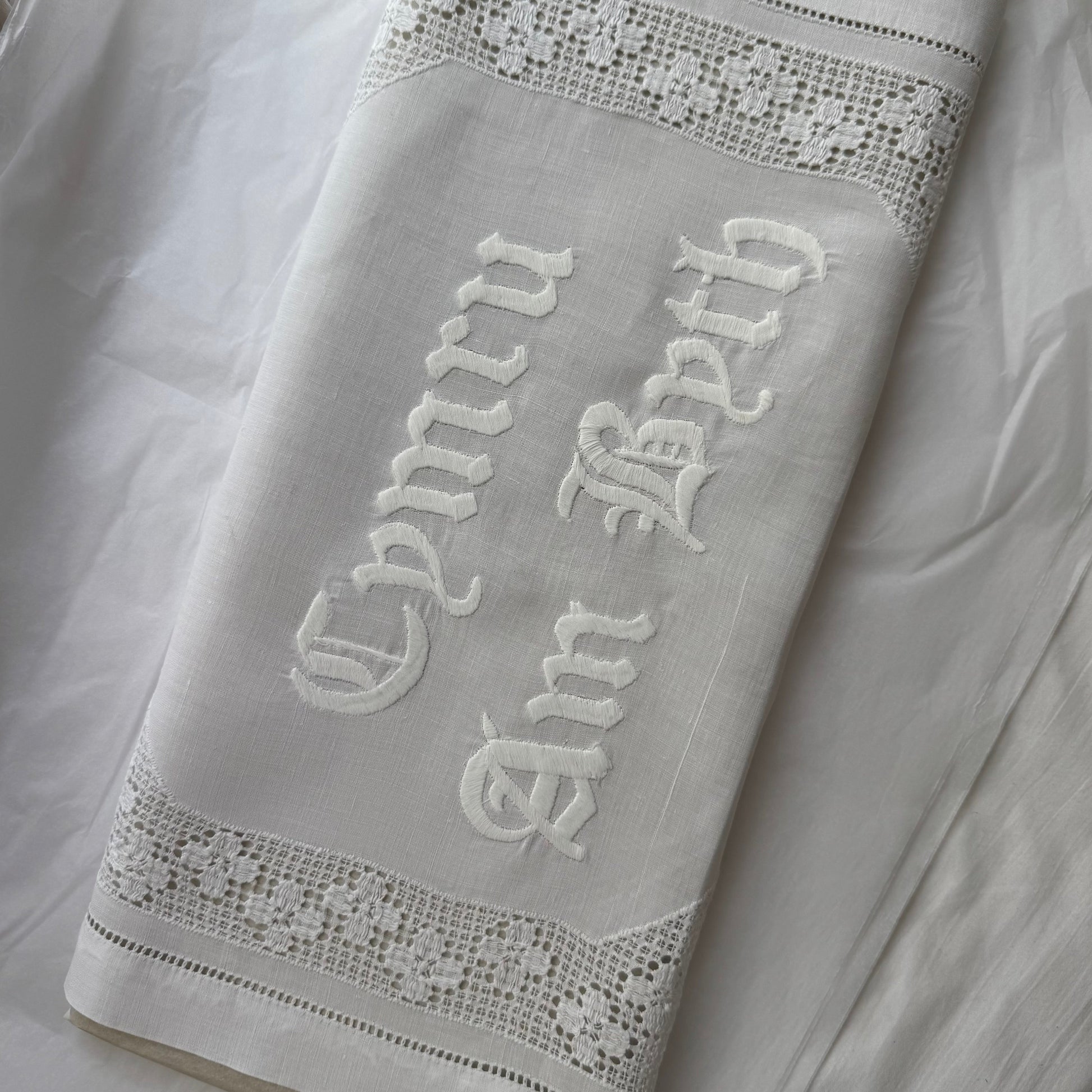 Embroidered text on a vintage fabric with decorative trim
