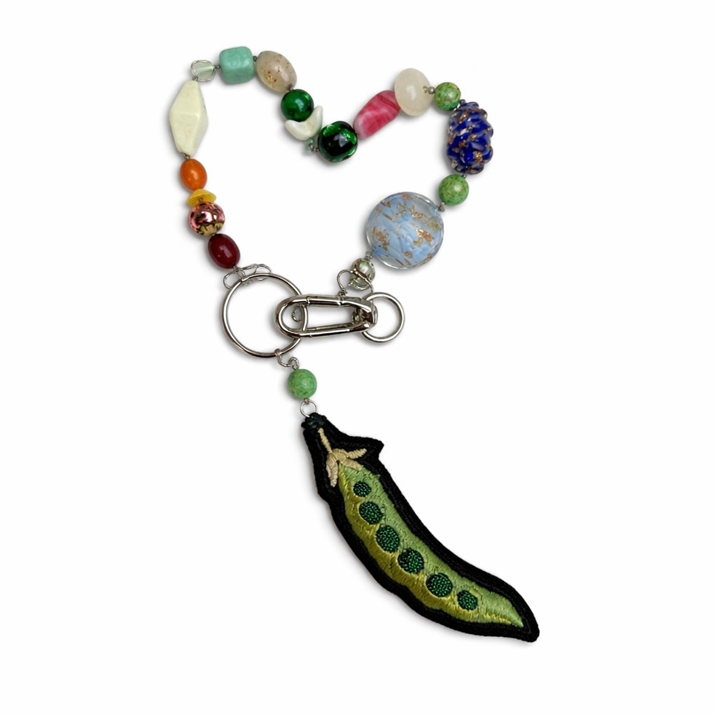 Colorful beaded keychain with a pea pod charm on a white background