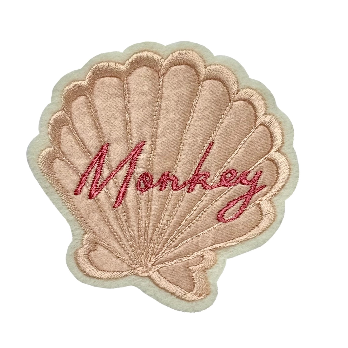 Silk applique shell patch on a white background. Has the word 'Monkey' embroidered in pink on the shell.