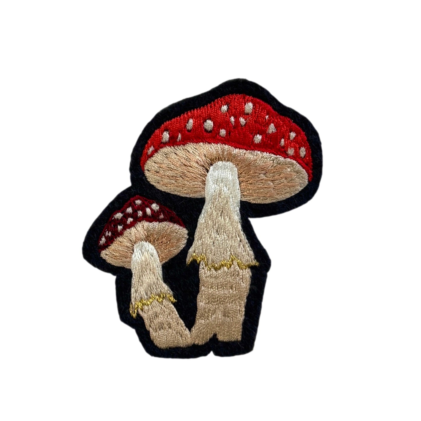 Embroidered patch of two mushrooms with red caps on a white background