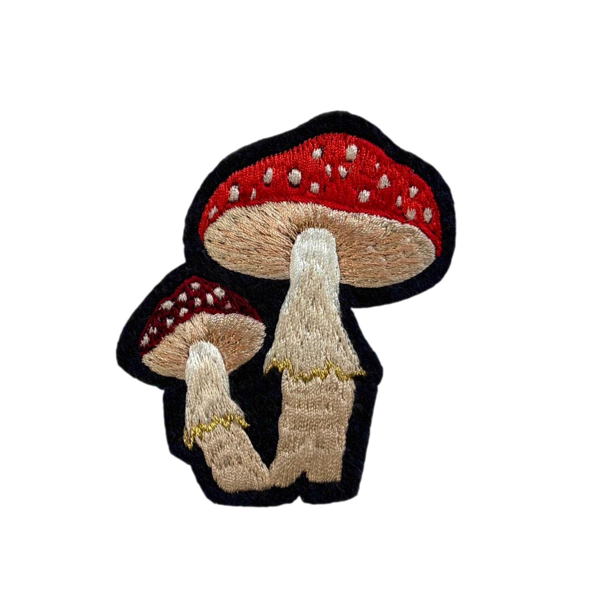 Embroidered patch of two mushrooms with red caps on a white background