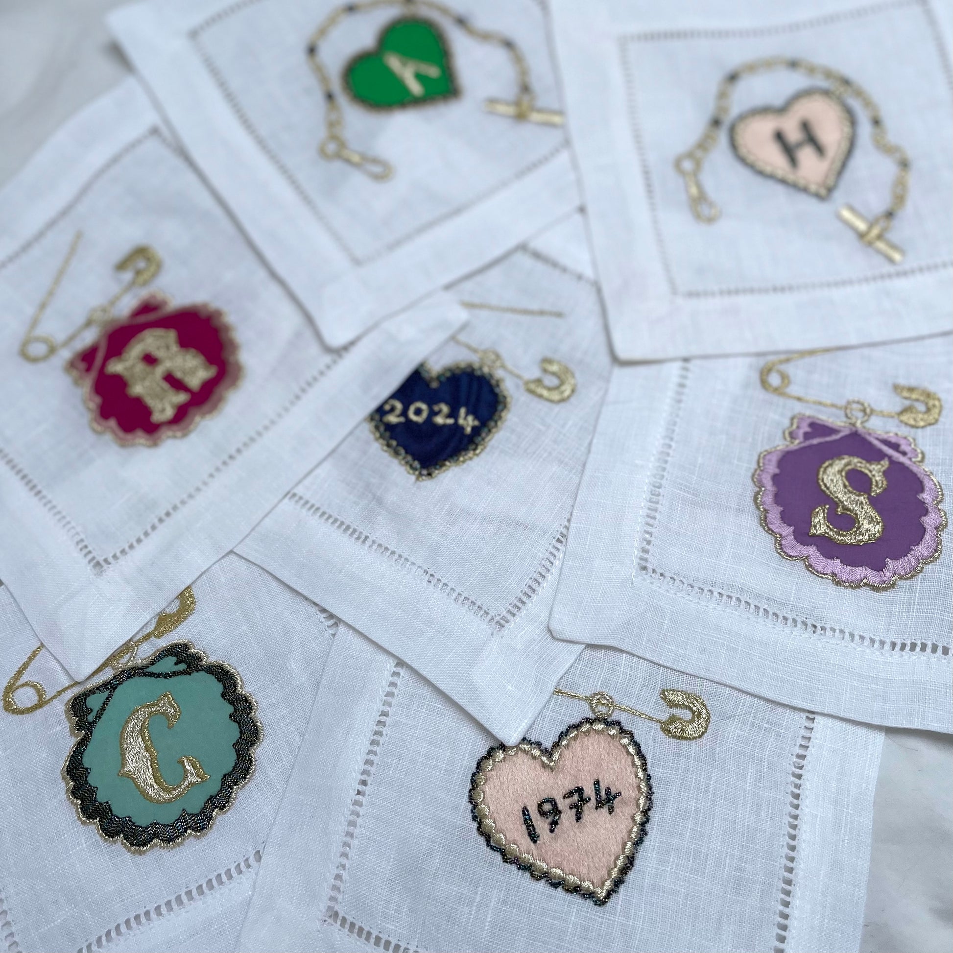 Mix of customised charm embroidered artworks, laying over the top of each other