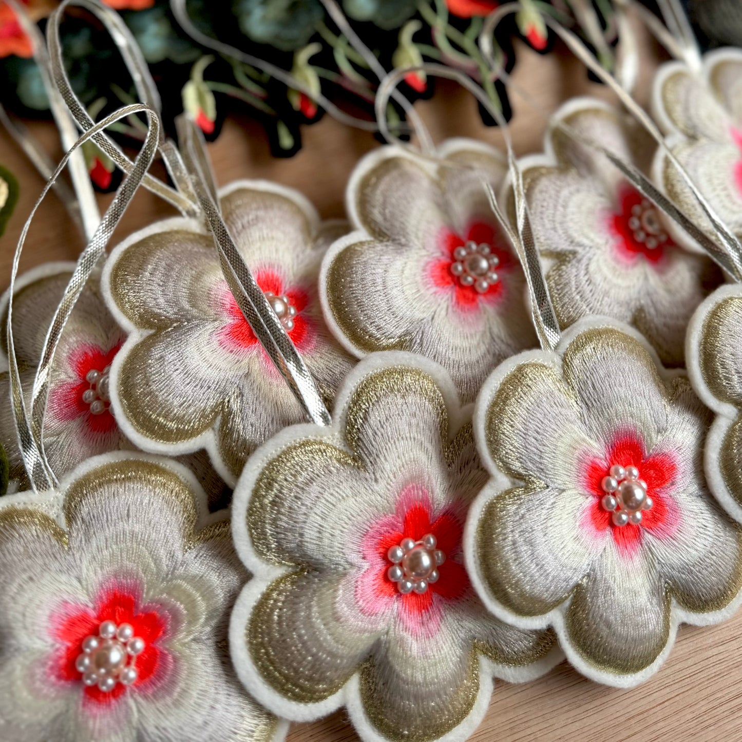 A collection of flower hanging decorations overlapping each other on a wood table