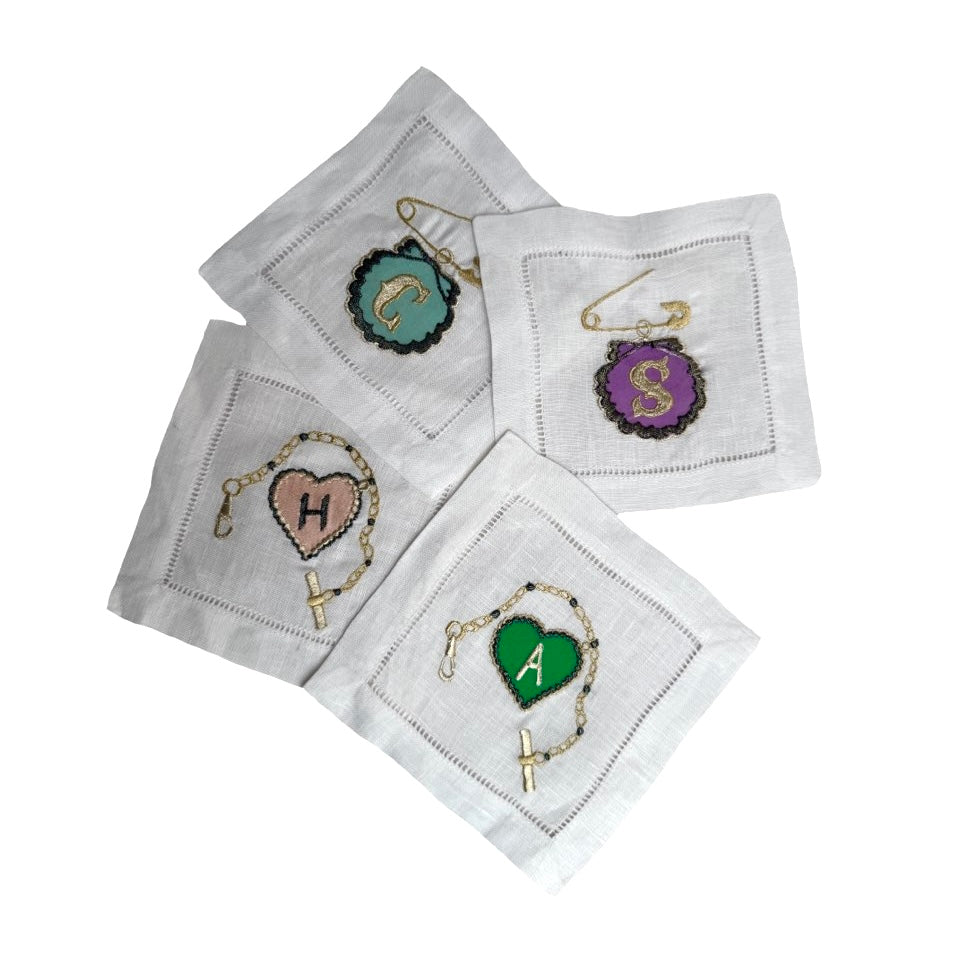 Set of four embroidered cocktail napkins with initials on a white background