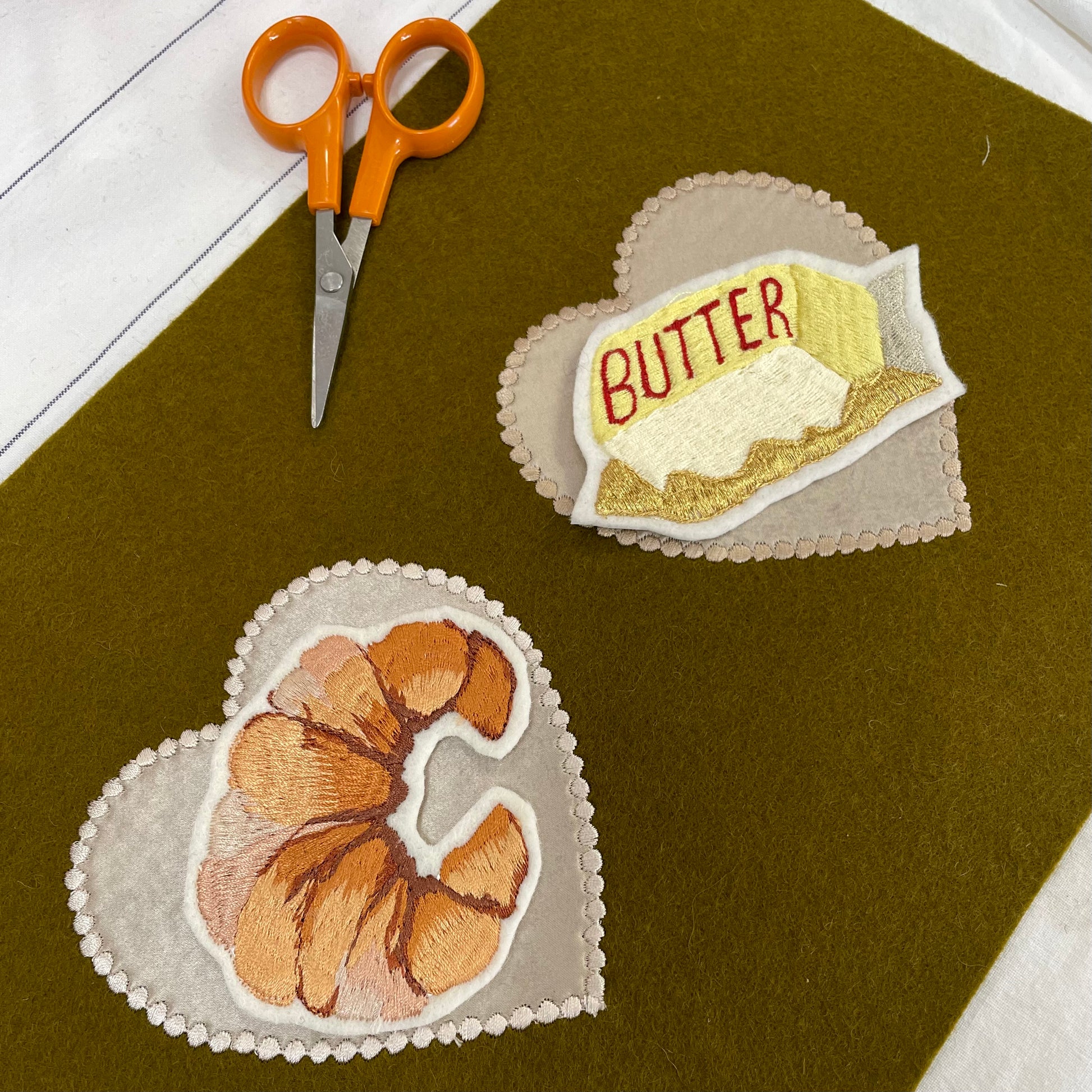 Croissant embroidered patch and butter embroidered patch on khaki felt background 