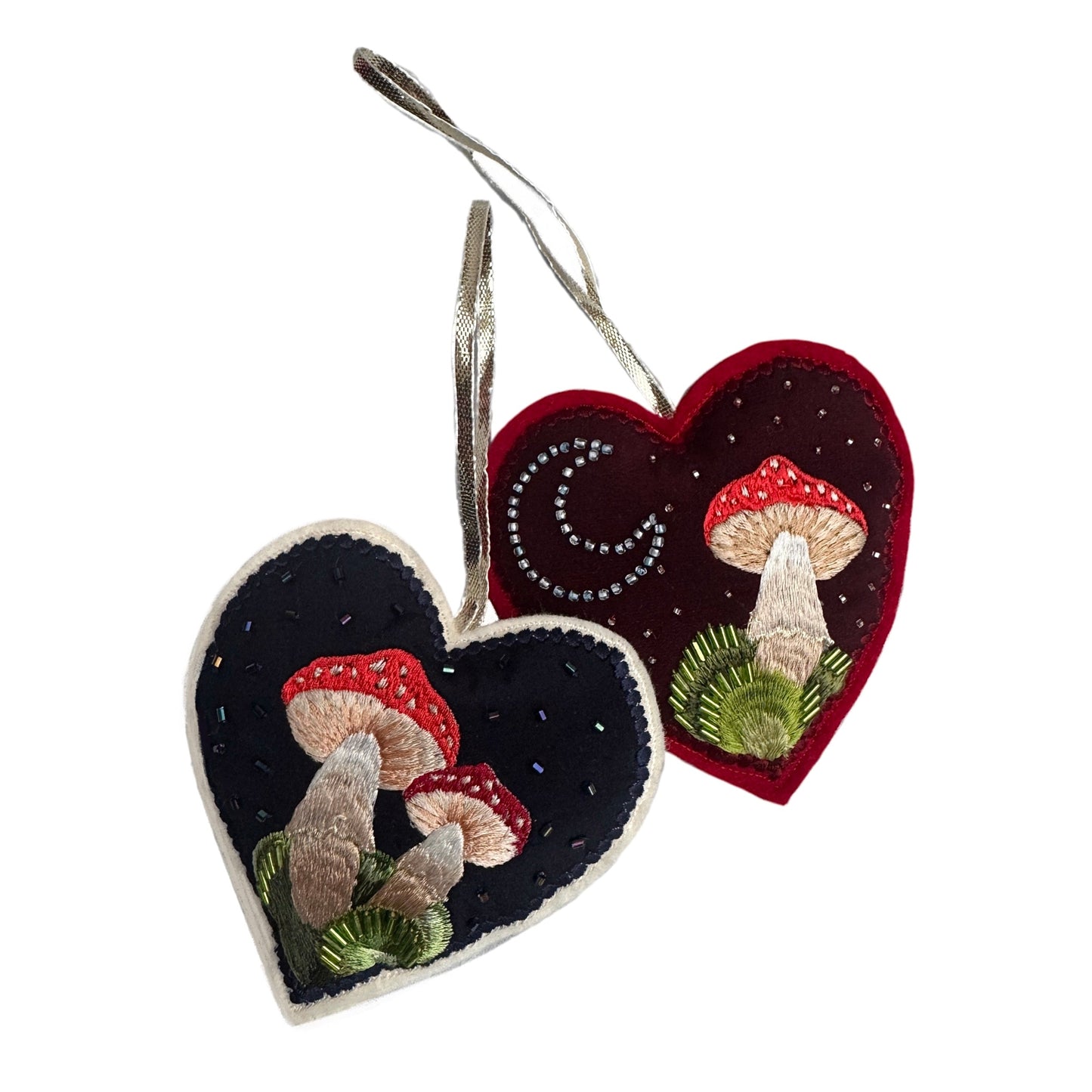 Heart-shaped embroidered ornaments with mushrooms on a white background