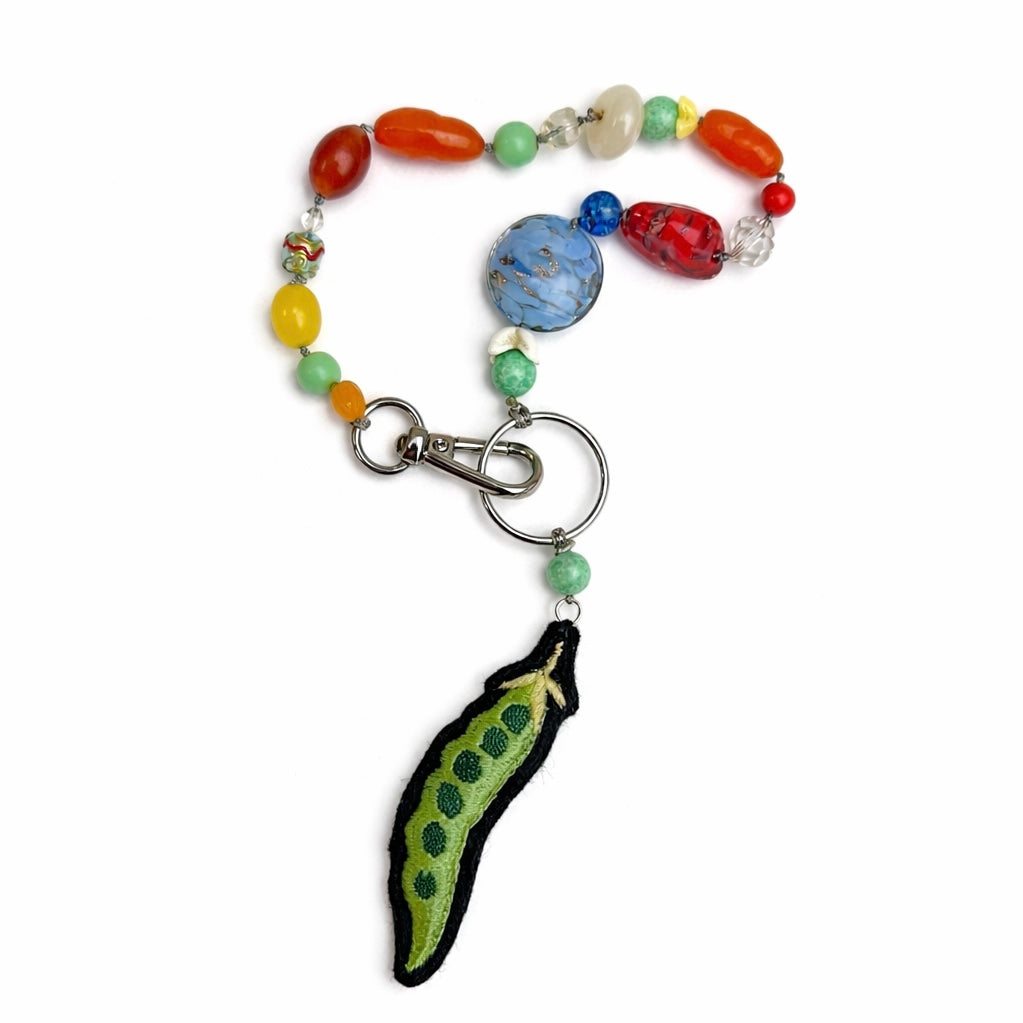 Colorful beaded keychain with a unique pea pendant on a white background