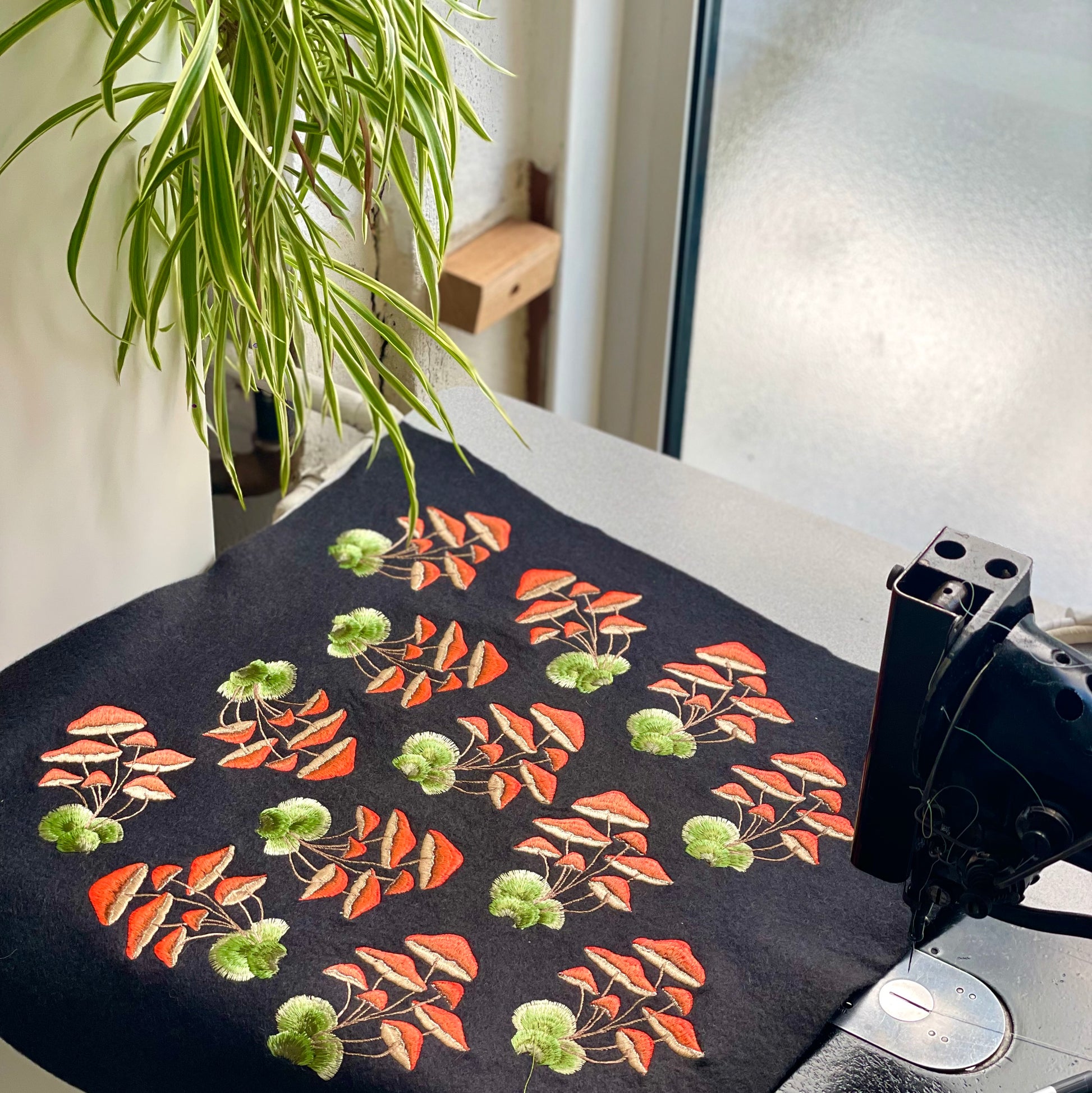 collection of pre-cut orange mushroom patches laid over the top of a vintage embroidery sewing machine