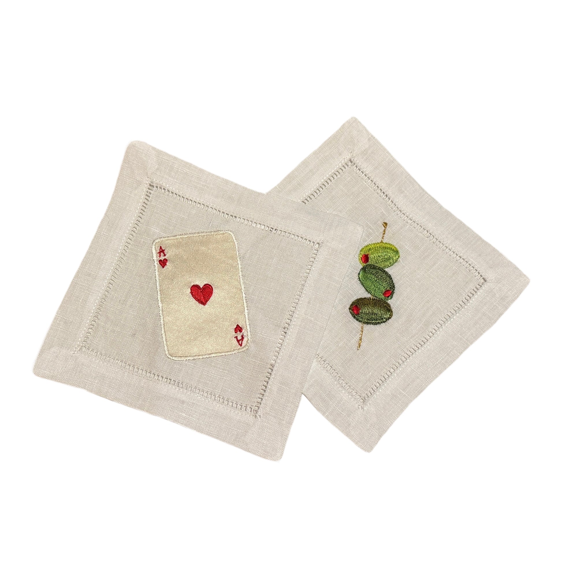 Two white coasters with embroidered designs on a white background