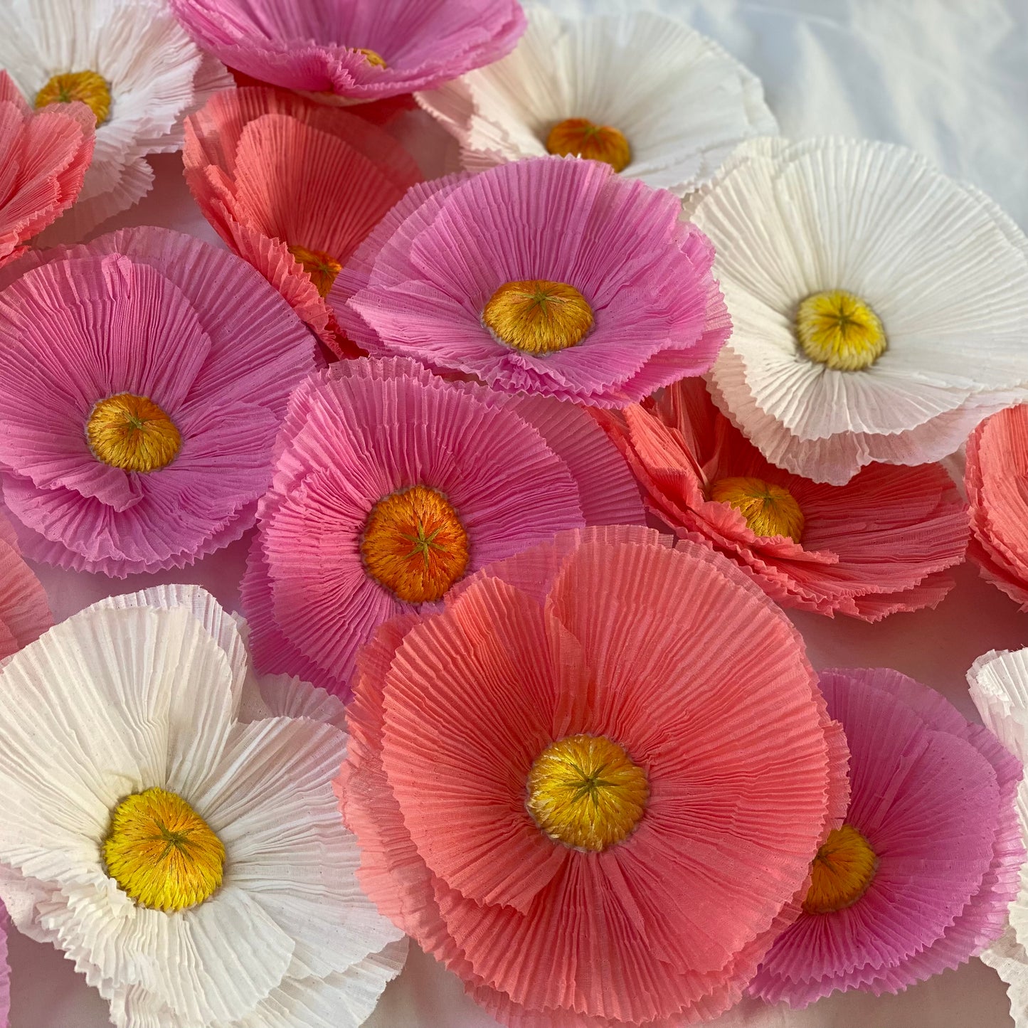 A mix of the original pleated fried egg flower embroideries mixed with pink versions of the flower