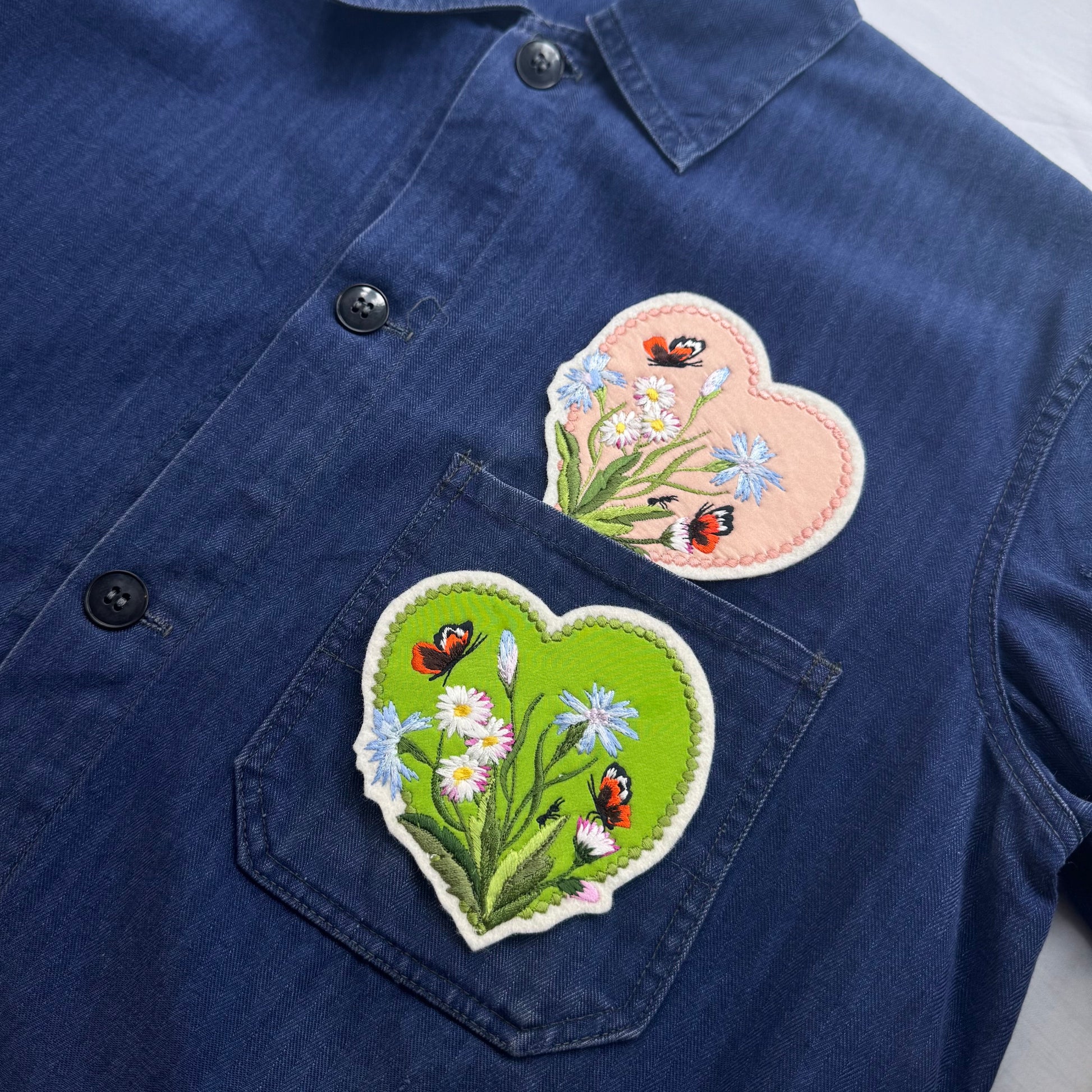 Navy blue shirt with heart-shaped floral patches featuring butterflies.
