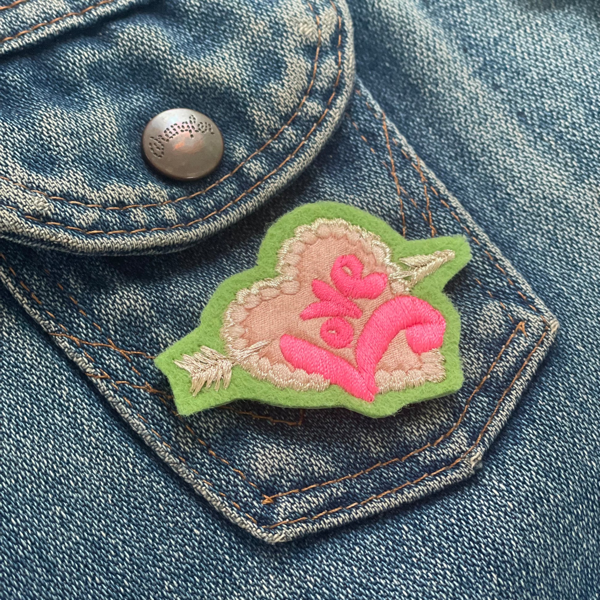 embroidered love pin on denim jacket