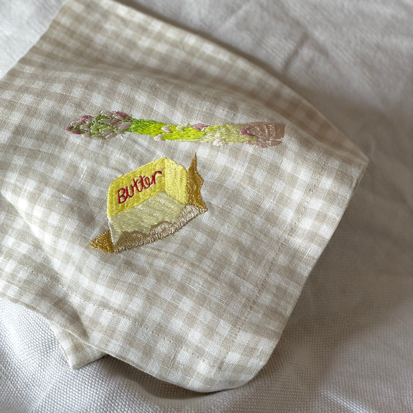 embroidered butter and asparagus on gingham napkin