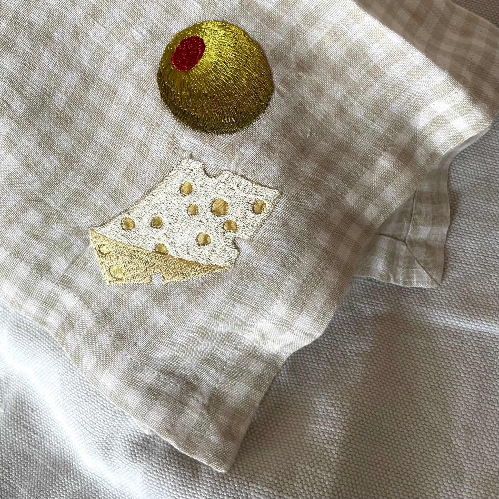 silk applique cheese with big olive on gingham napkin