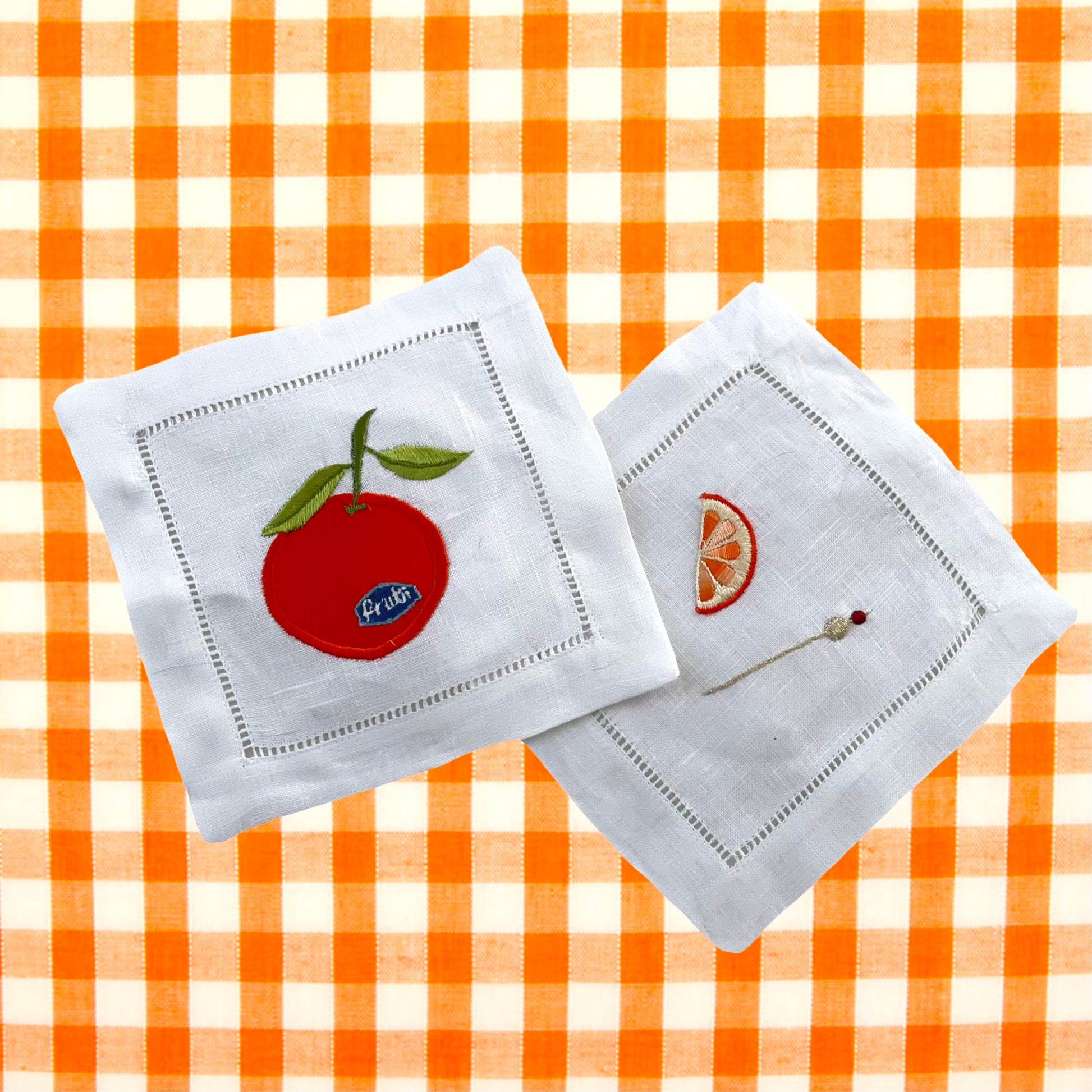 Orange and orange segment embroidered drinks coasters on orange and white gingham background