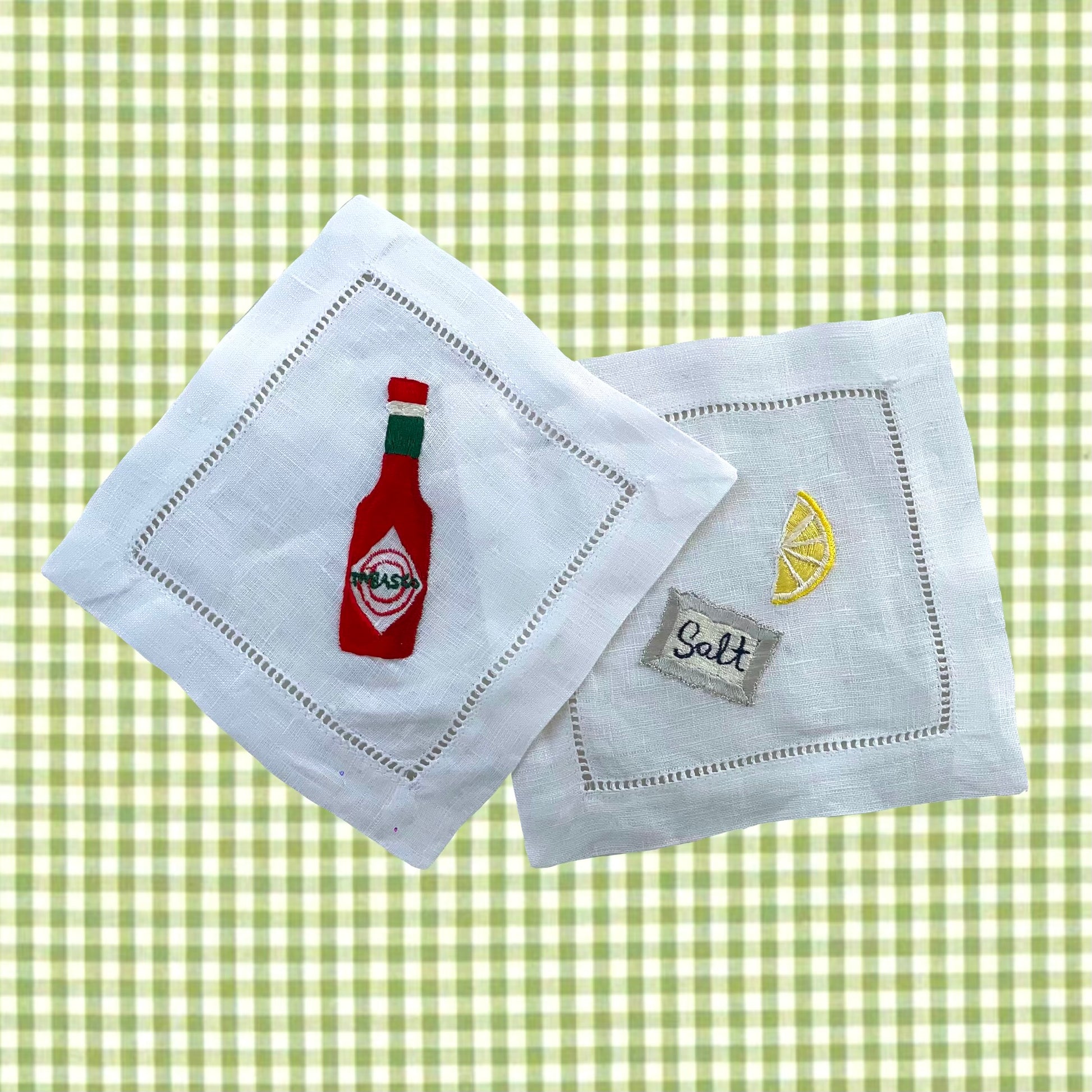 Tabasco and salt packet embroidered drinks coasters shown on pale green and white linen background