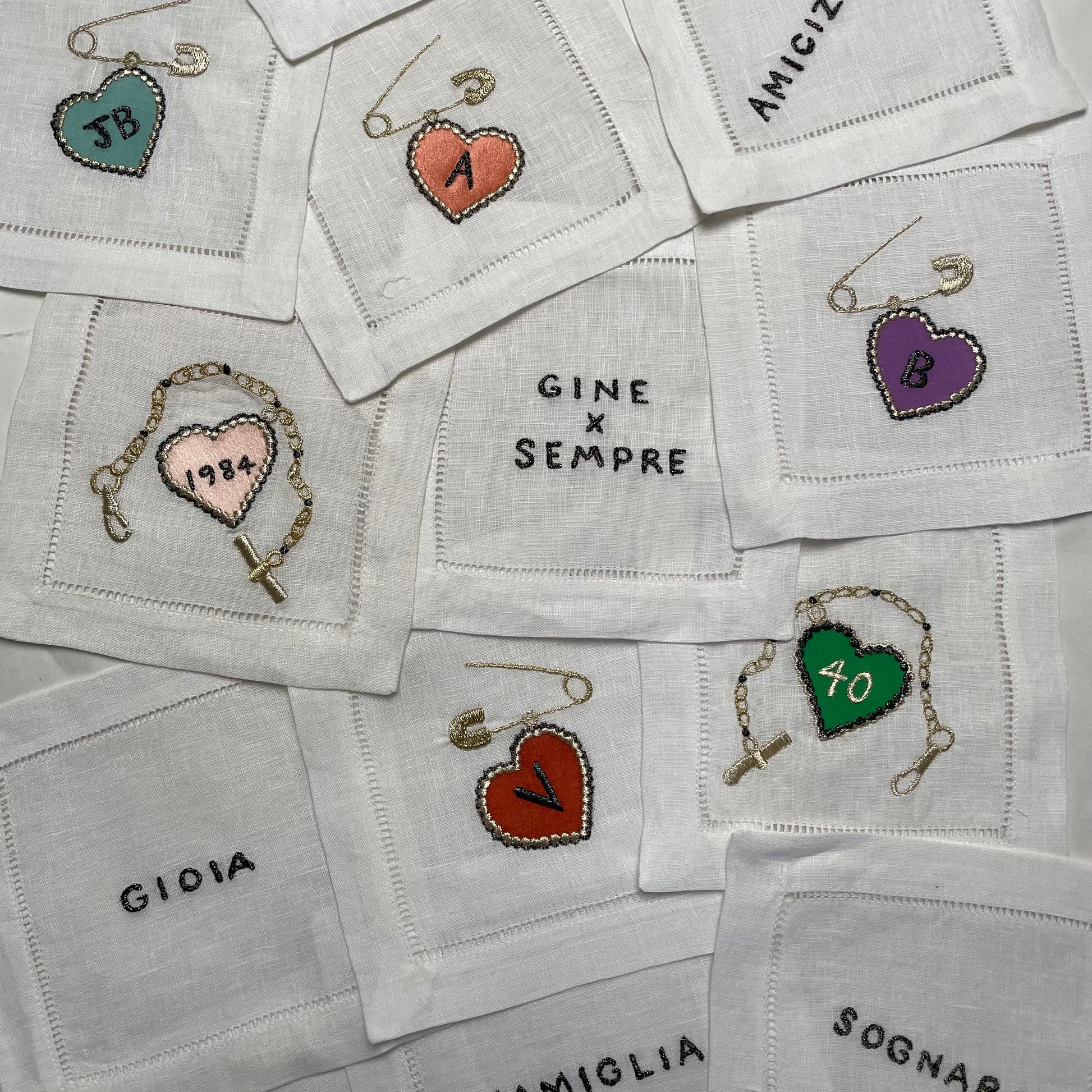 White coasters with embroidered heart designs and text on a white background