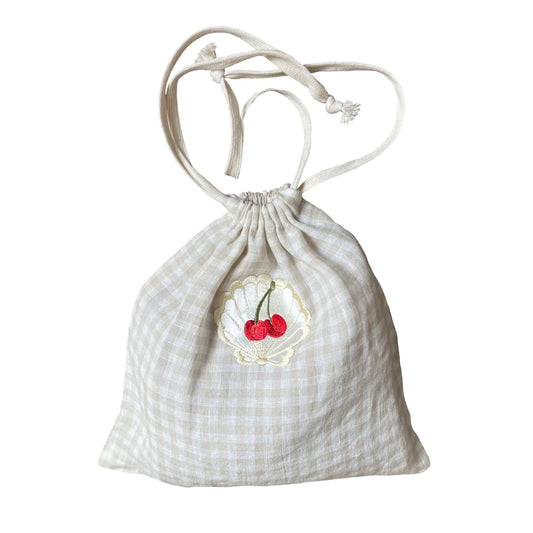 Linen drawstring bag with embroidered cherry motif on white background