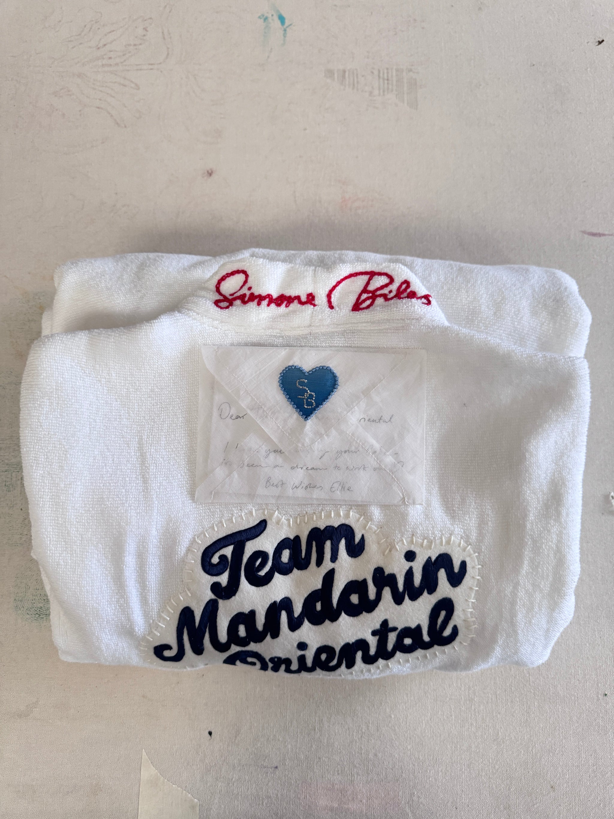 White towel with 'Team Mandarin Oriental' text on a light gray background