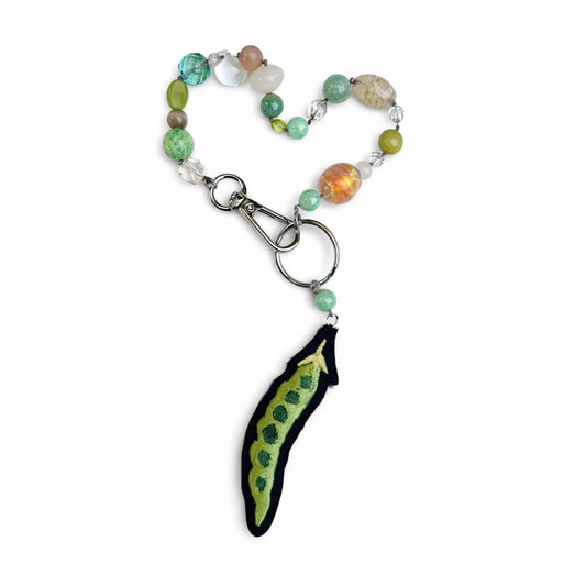 Beaded keychain with a unique pea pendant on a white background