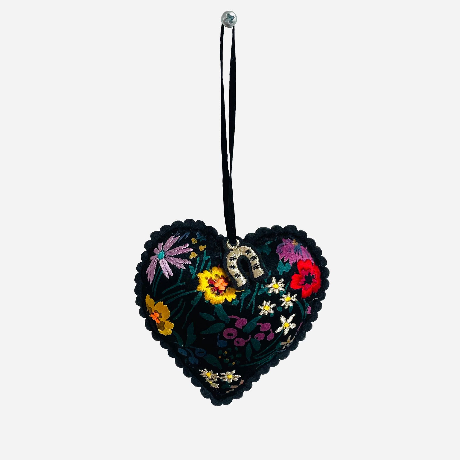 Embroidered padded silk heart on white background