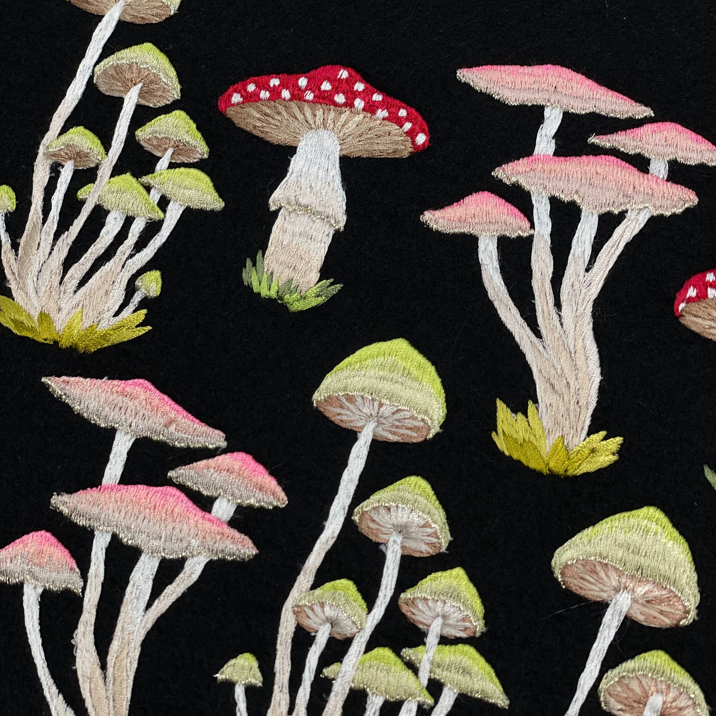 Selection of different embroidered mushrooms on black background