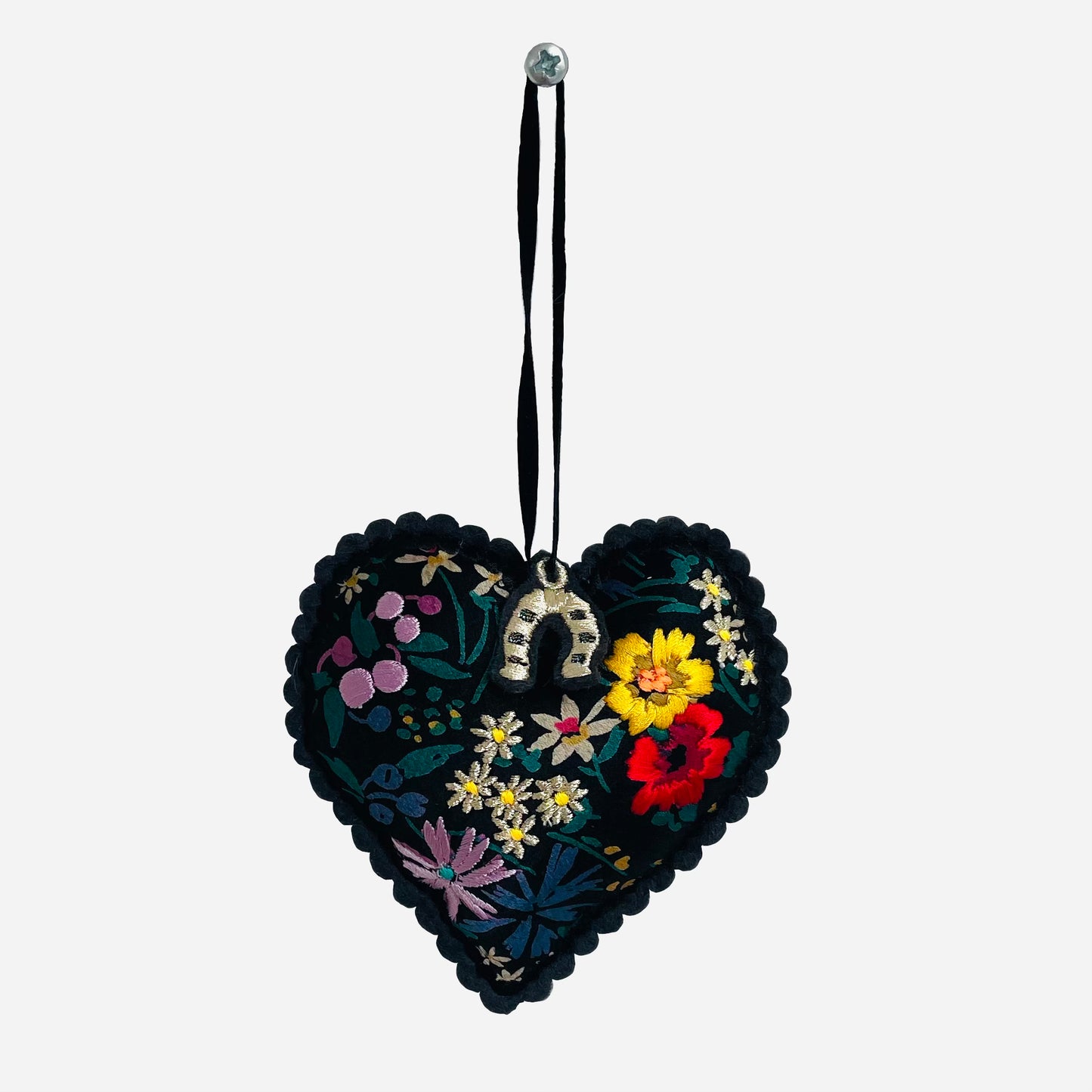 Embroidered padded silk heart on white background