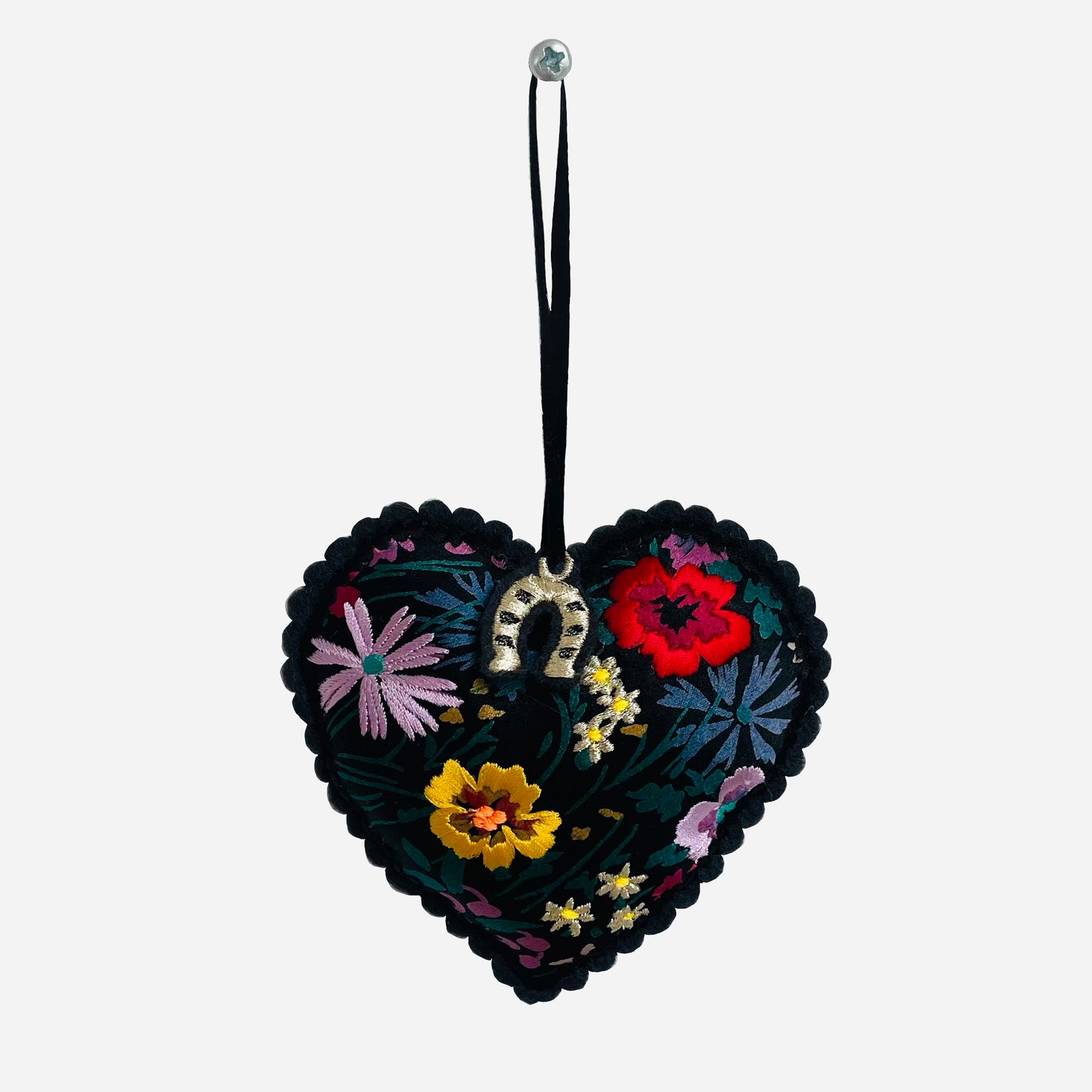 Embroidered padded silk heart on white background