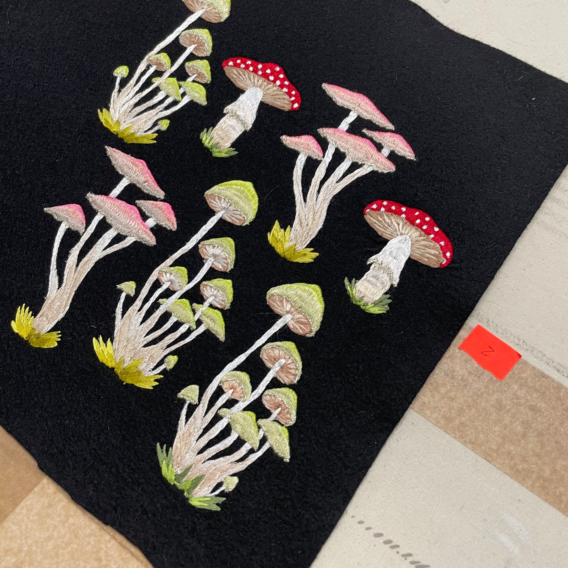 Various embroidered mushroom designs on black felt