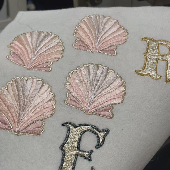 Video of pre-cut peach shell embroidered patches on cream felth