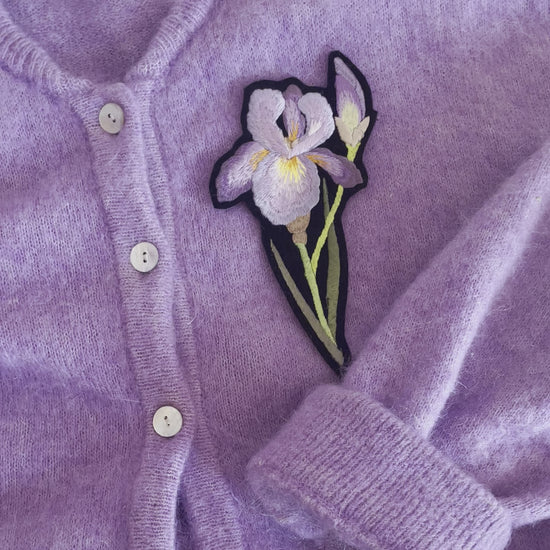 Video of the lilac iris embroidered patch on a lilac knitted cardigan