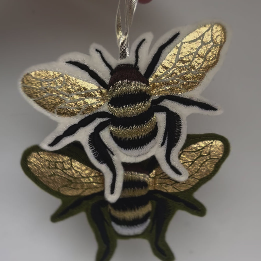 Video of bee decorations twisting left to right to show metallic foiled wings