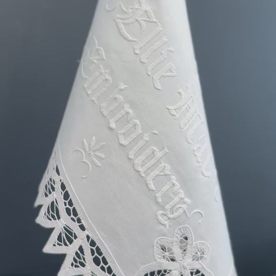 video of vintage linen with white embroidered text