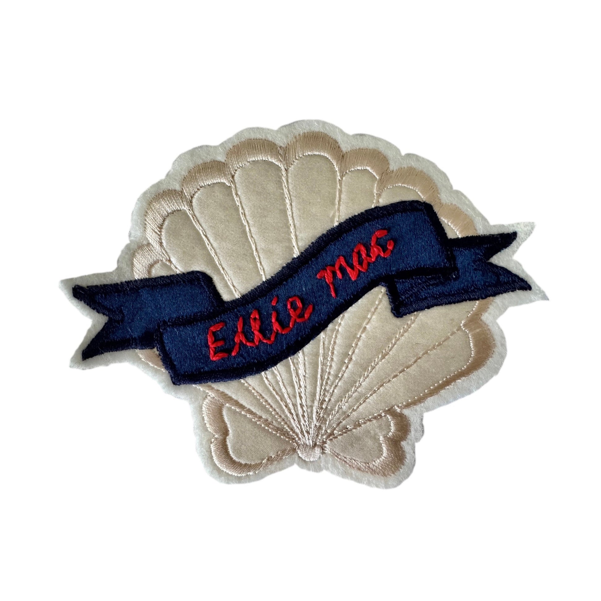 Seashell patch with a blue banner and red text on a white background